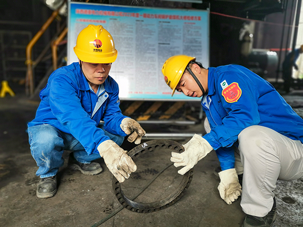 圖三：12日下午14時(shí)，在一期磨煤機(jī)廠房，陜西省技術(shù)能手姬霄給青工張跟潮講解磨煤機(jī)搖臂曲拐內(nèi)環(huán)及動(dòng)作原理。.jpg
