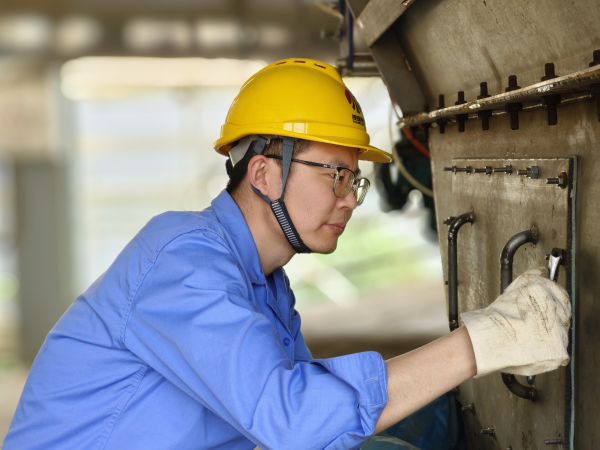 5月11日，尿素車間設(shè)備技術(shù)員馬強(qiáng)檢查設(shè)備螺栓是否松動(dòng).jpg